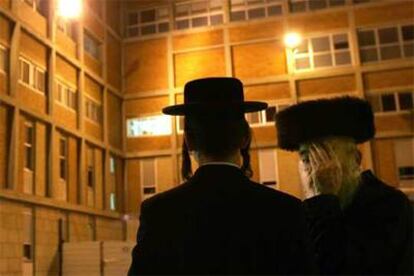 Dos judíos ultraortodoxos, delante del hospital de Jerusalén donde se encuentra Sharon.