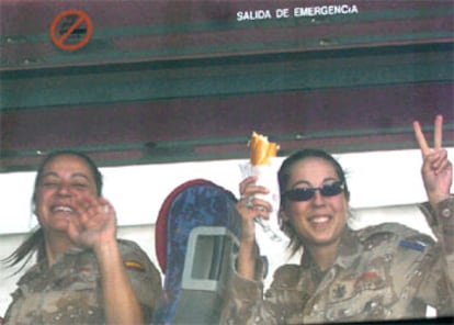 Una soldado del contingente de 145 militares llegados hoy a España saluda desde el autocar que los trasladó de Madrid a Valladolid.