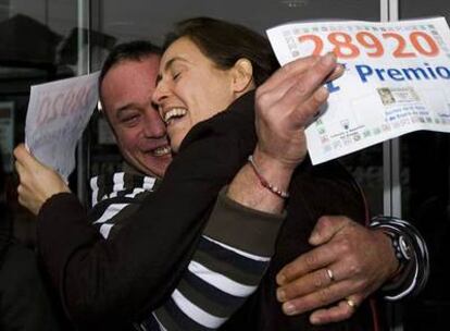 Carlos, uno de los premiados, se abraza a la lotera, Pilar Antequera, ayer en Terrassa.