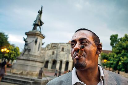 Un viandante de Santa Domingo, junto al monumento a Cristóbal Colón.