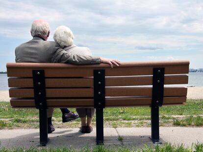 Pareja mayor sentado en el banco del parque.