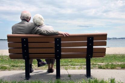 Pareja mayor sentado en el banco del parque.