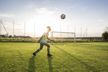 Uma criança joga com sua bola.