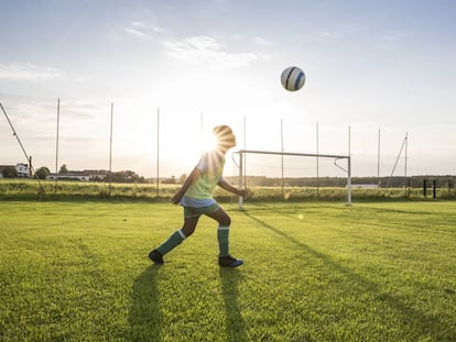 Uma criança joga com sua bola.