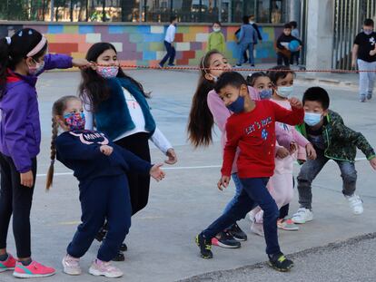 Una decena de niños juegan con la mascarilla puesta en el colegio Auró de Terrassa.