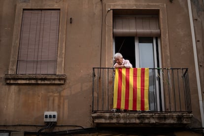 Una mujer coloca una bandera independentista catalana en su balcón, este miércoles en Barcelona.