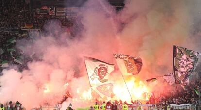 Los seguidores del Borussia Moenchengladbach encienden bengalas durante el partido de vuelta contre el Lazio.