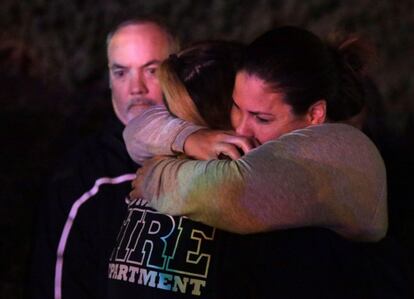 Una mujer que ha huido del lugar del tiroteo abraza a sus familiares, en el Borderline Bar&Grill, en la localidad de Thousand Oaks, en las afueras de Los Ángeles.