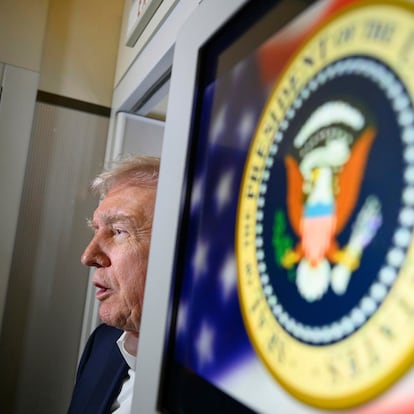 President Donald Trump talks to reporters on board Air Force One on the way to Palm Beach International Airport, in West Palm Beach, Fla., Friday, April 11, 2025. (Pool via AP)