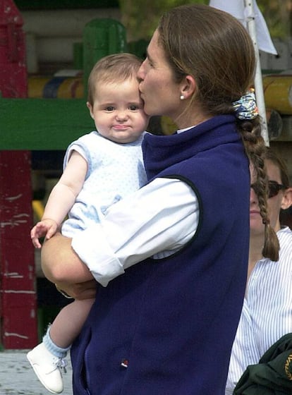 La infanta Elena sostiene en brazos y besa a su hija Victoria Federica, en un descanso de la competición hípica en la que participa la duquesa de Lugo, en Valladolid, el 11 de mayo de 2001.