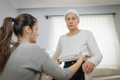 Imagen de archivo de una mujer vistiendo a su madre.