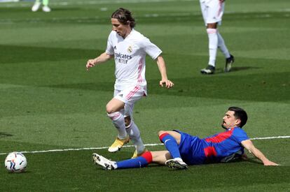 El centrocampista croata del Real Madrid, Luka Modric, lucha por el balón con el centrocampista del Eibar Sergio Álvarez Díaz.