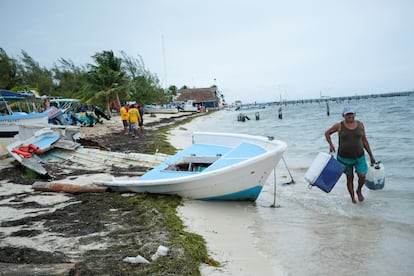 Un hombre lleva una nevera y un tanque de gasolina mientras el huracán Helene se aproxima a la Península de Yucatán, este martes en Cancún.