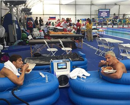 Los nadadores estadounidenses Michael Phelps (i) y Ryan Lochte cogen fuerzas comiendo pasta a horas de iniciarse la final de 200 metros estilos.