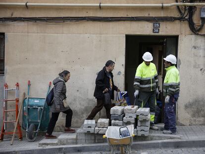 Vecinos del edificio de viviendas  “El Barco” en Esplugues del Llobregat retiran sus pertenencias mientras unos operarios se preparan para tapiar.