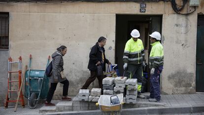 Vecinos del edificio de viviendas  “El Barco” en Esplugues del Llobregat retiran sus pertenencias mientras unos operarios se preparan para tapiar.