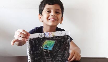 Saahil, uno de los niños que viven en el campamento de Cheda Nagar, al noroeste de Bombay, muestra orgulloso su dibujo sobre cómo está viviendo el confinamiento.