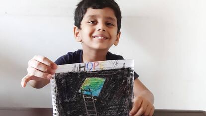 Saahil, uno de los niños que viven en el campamento de Cheda Nagar, al noroeste de Bombay, muestra orgulloso su dibujo sobre cómo está viviendo el confinamiento.