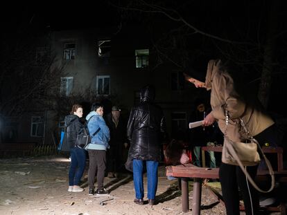 Varias personas observaban un edificio de apartamentos de tres plantas dañado tras un ataque ruso con drones el 4 de abril de 2024 en Járkov.