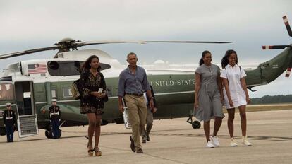 Malia Obama, de blanco, anda con sus padres y su hermana a su vuelta de las vacaciones este domingo.