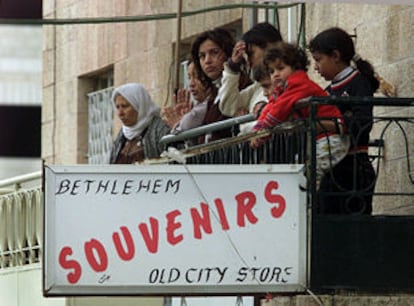 Una familia palestina se asoma al balcón en Belén, tomada por el Ejército israelí.