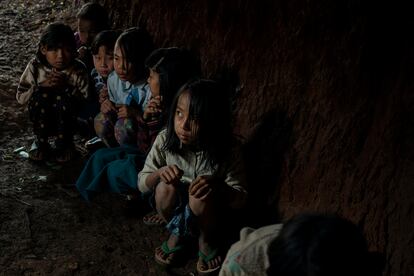 Unos niños se esconden en un refugio antibombas de su colegio durante un simulacro de emergencia en caso de un bombardeo de mortero de las fuerzas gubernamentales, con una base a pocos kilómetros de la ciudad, en el estado de Kayah, al este de Birmania, el 24 de octubre de 2022.  Los niños hacen estos simulacros con regularidad en caso de ataque. Su pueblo ha sido bombardeado tres veces el pasado año. Según Naciones Unidas, miles de personas han sido asesinados, 1.4 millones de personas han sido desplazadas y un tercio de la población necesita ayuda humanitaria.