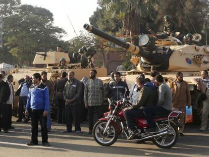 Un grupo de partidarios de los Hermanos Musulmanes, junto a los tanques que vigilan los muros del palacio presidencial de El Cairo.