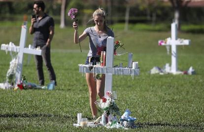 Una joven deposita unas flores en el homenaje a las víctimas en Parkland.