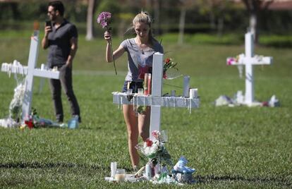 Una joven deposita unas flores en el homenaje a las v&iacute;ctimas en Parkland. 