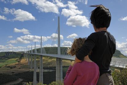 Una madre y un hijo miran el viaducto de MIllau, en el departamento francés de Aveyron, el más alto del mundo.