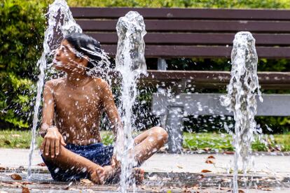 Un niño se refresca en una fuente de agua en un parque de Palma de Mallorca.