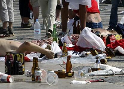 Seguidores ingleses al sol, en la plaza del Rossio, entre botellas de cerveza vacías y desperdicios.