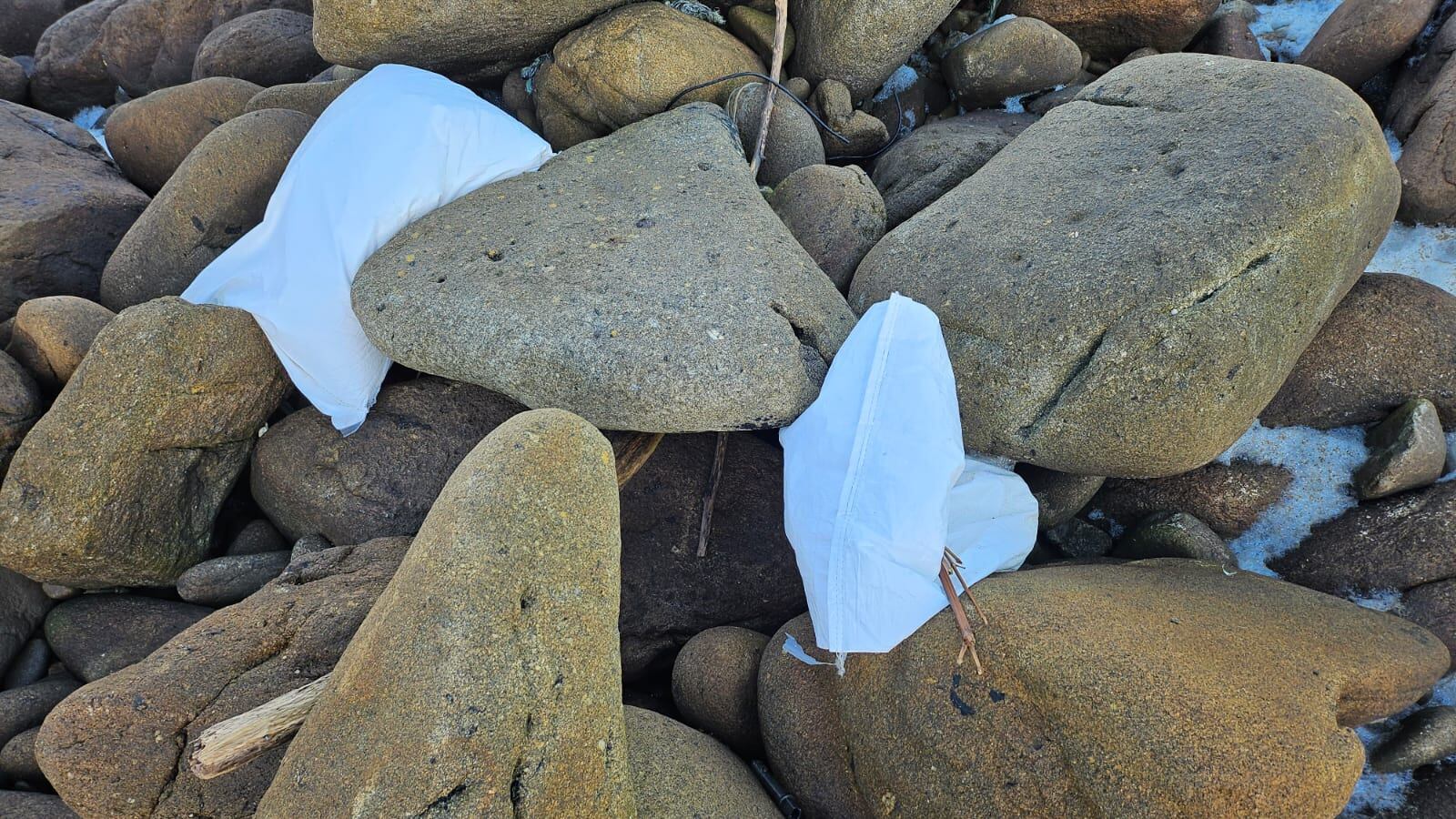 Sacos enteros de 'pellets' entre las piedras del faro de Corrubedo (Ribeira) el pasado 13 de diciembre, en una de las fotos utilizadas por Rodrigo Fresco para alertar de la marea.