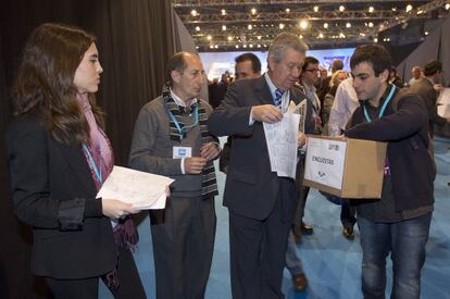 Atenea Chevillotte y un colaborador recogen encuestas de los compromisarios del PP en el congreso de Sevilla.