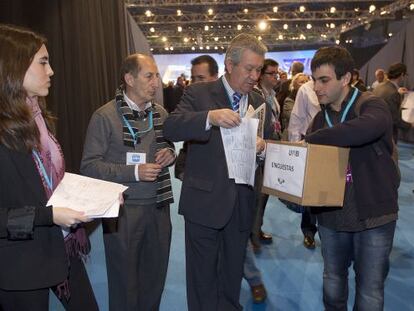 Atenea Chevillotte y un colaborador recogen encuestas de los compromisarios del PP en el congreso de Sevilla.