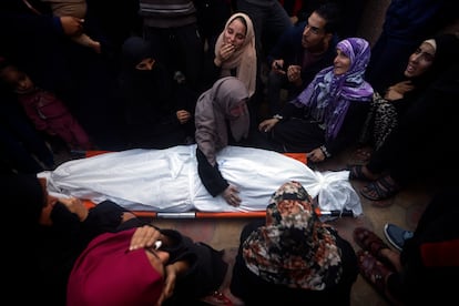 Familiares y amigos lloraban sobre el cadáver de una persona muerta en los ataques israelíes, este lunes en la morgue del hospital en Jan Yunis. 