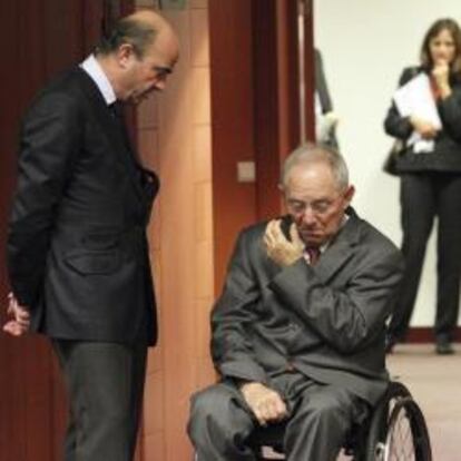 El ministro español de Economía y Competitividad, Luis de Guindos, dialoga con el ministro alemán de Finanzas, Wolfgang Schäuble, eñ 4 de diciembre de 2012 en la reunión del Ecofin, en Bruselas.