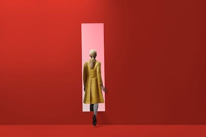 Woman walking into rectangular opening in coloured wall