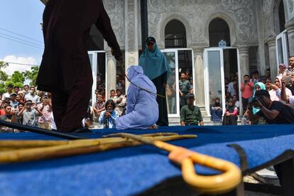 Una multitud ve como un policía de la Sharia azota públicamente a una mujer en Banda Aceh (Indonesia), el 20 de marzo de 2019. Cinco parejas fueron condenadas a recibir entre 10 y 20 golpes con una vara de madera como castigo por verse a solas sin estar casados.
