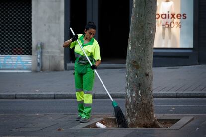 Una trabajadora del Ayuntamiento de Barcelona barre sin mascarilla en la Rambla.