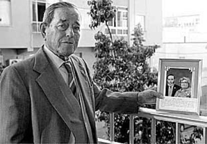 José Magaña, en su casa de Almería, muestra una foto antigua suya y de su esposa.