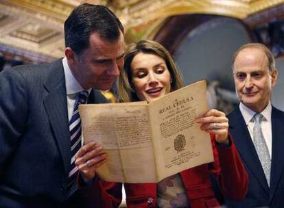 Los Príncipes leen un documento  junto al director  de la Biblioteca Pública de Nueva York, Paul LeCerc.