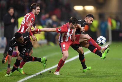 Saúl Niguez del Atlético y Karim Bellarabi del Leverkusen luchan por el balón durante el partido de Champions. 