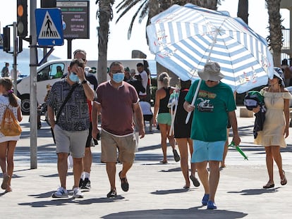 Un hombre se protege del intenso calor con una sombrilla de playa por las calles de la ciudad de Alicante a mediados del pasado julio.