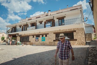 Un hombre camina frente al hostal de Griegos (Teruel) ofertado para atraer familias a la localidad.