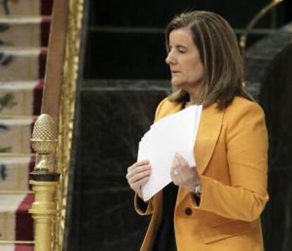 La ministra de Empleo, Fátima Báñez, se dirige a la tribuna de oradores para intervenir hoy en el pleno del Congreso.