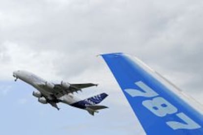 The vertical stabilizer of a Boeing 787 Dreamliner as an Airbus A380 takes off during the 49th Paris Air Show at the Le Bourget airport near Paris.