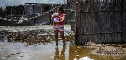 Una mujer con su niño en una calle inundada en el norte del Peru
