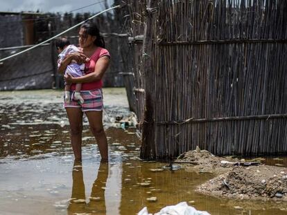 Una mujer con su ni&ntilde;o en una calle inundada en el norte del Peru