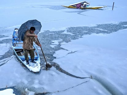 Un hombre navega con su bote en erl Lago Dal, durante la nevada del 13 enero, en Srinagar (India).